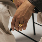 Men’s signet ring worn on hand with bracelets