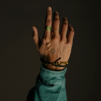 Men’s signet ring worn on hand with bracelets